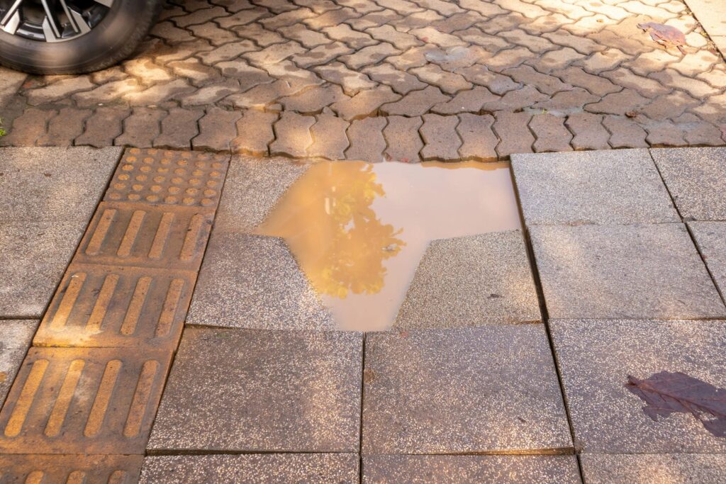 muddy puddle forming in sinking paver patio